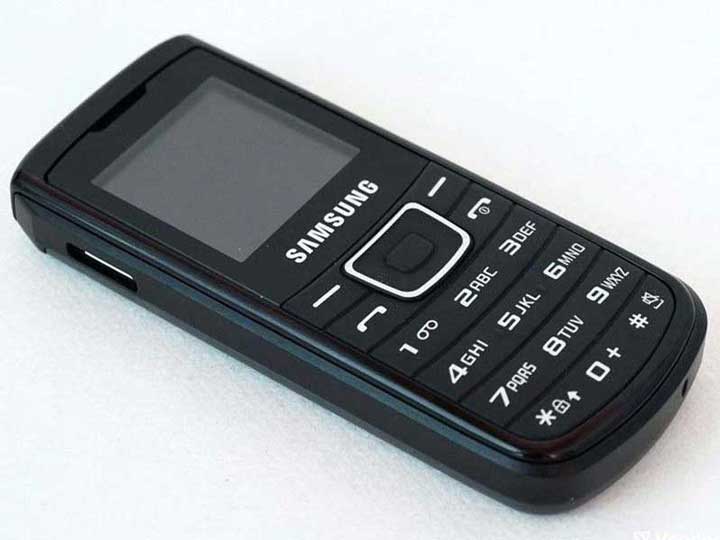 Close-up of the classic Samsung E1100 mobile phone with a numeric keypad.
